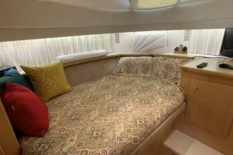 Contentment Yacht Photos Pics Cozy bedroom in 1995 Carver 440 Aft Cabin Motor Yacht with patterned bedding and colorful pillows.