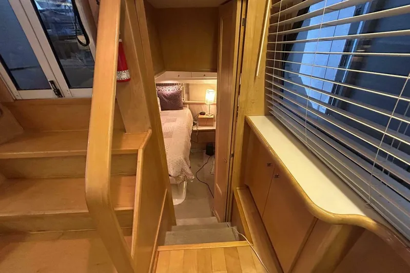 Contentment Yacht Photos Pics Interior of 1995 Carver 440 Aft Cabin Motor Yacht, featuring cozy bedroom and wooden stairs.