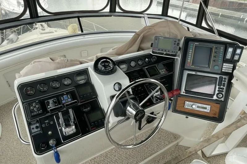 Contentment Yacht Photos Pics 1995 Carver 440 Aft Cabin Motor Yacht helm with navigation instruments and steering wheel.