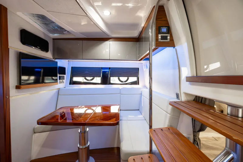 New Trade-in- All Offers & Trades Welcome Yacht Photos Pics Luxurious interior of 2021 Boston Whaler 405 Conquest with elegant seating and wooden table.