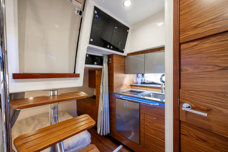New Trade-in- All Offers & Trades Welcome Yacht Photos Pics Luxurious interior of 2021 Boston Whaler 405 Conquest yacht with modern kitchen and wooden finishes.