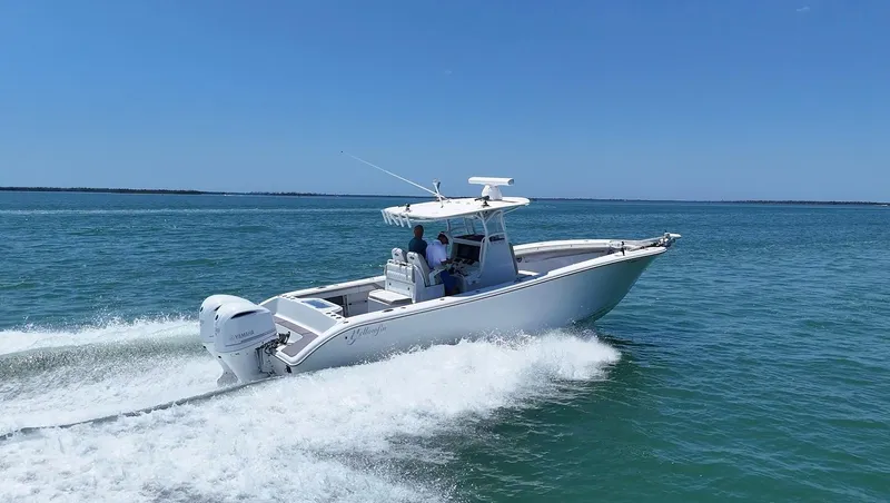  Yacht Photos Pics 2016 Yellowfin 32 Offshore boat cruising on open water, clear blue sky.