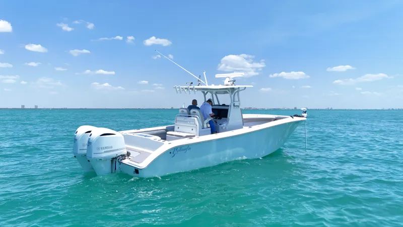  Yacht Photos Pics 2016 Yellowfin 32 Offshore boat cruising on clear blue water under a sunny sky.