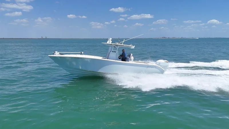  Yacht Photos Pics 2016 Yellowfin 32 Offshore boat cruising on open water under a clear blue sky.