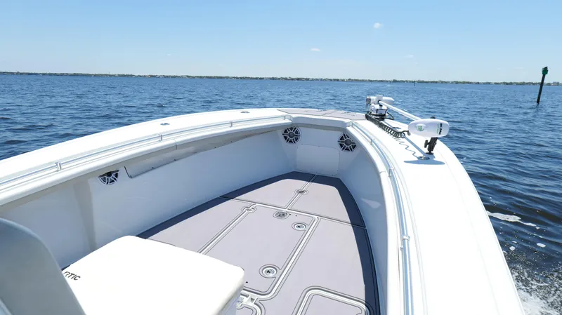  Yacht Photos Pics 2016 Yellowfin 32 Offshore boat on calm water, showcasing spacious deck and sleek design.