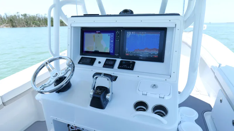  Yacht Photos Pics 2016 Yellowfin 32 Offshore boat dashboard with navigation screens and steering wheel.