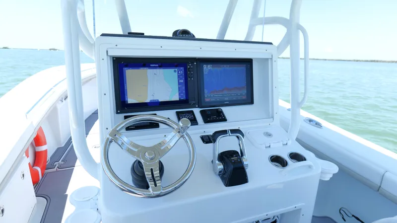  Yacht Photos Pics 2016 Yellowfin 32 Offshore boat dashboard with navigation screens and steering wheel.