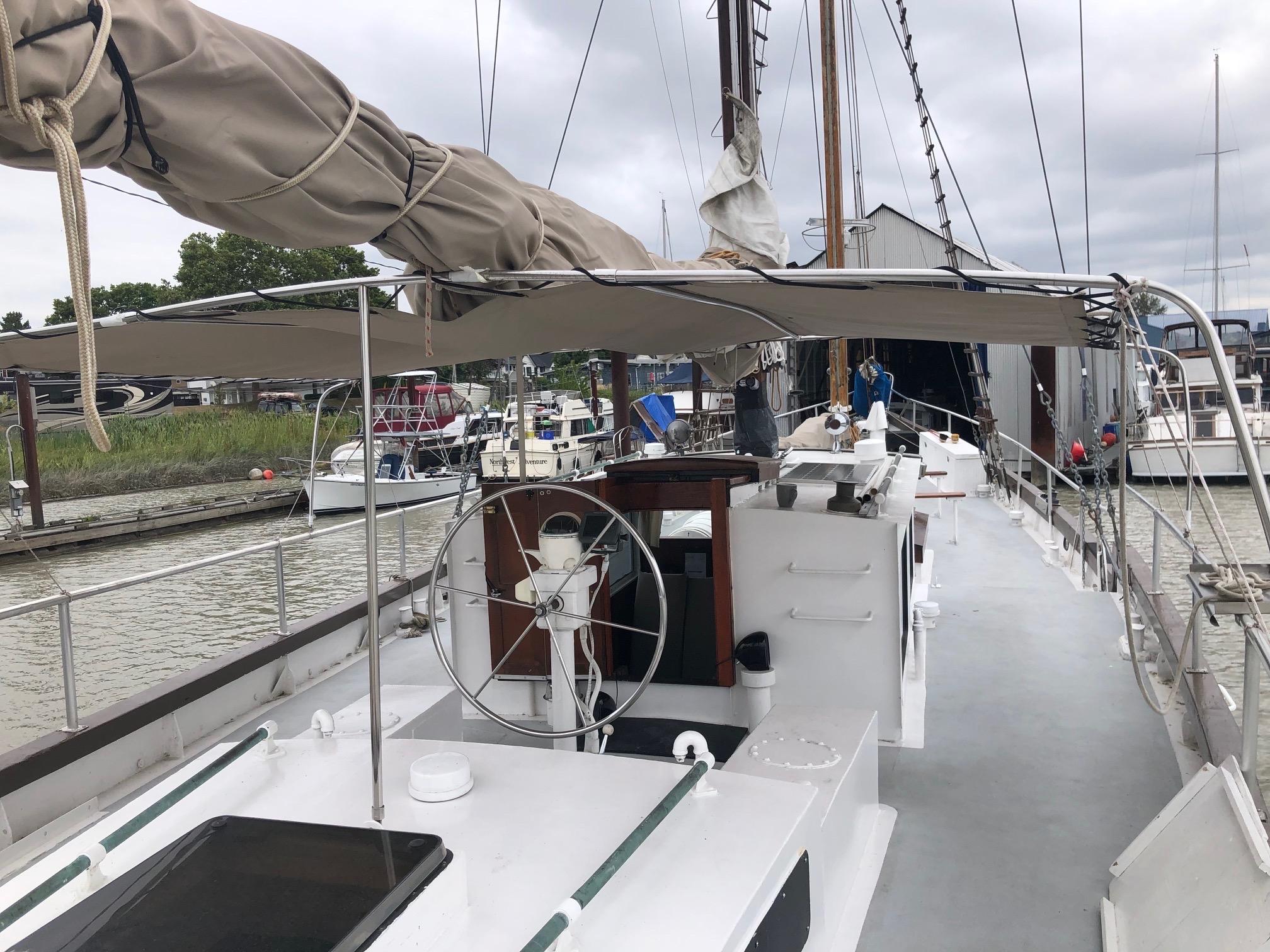 1975 Custom Staysail Schooner docked at marina, featuring deck and steering wheel.