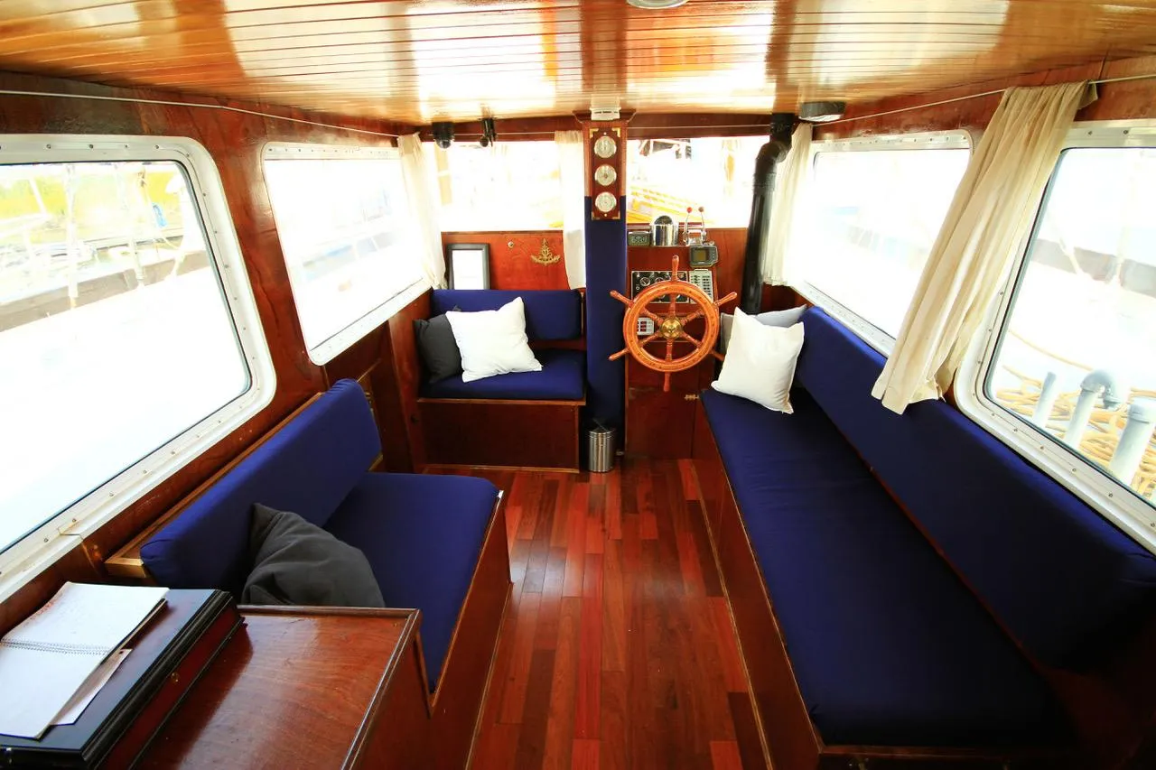 Interior of 1975 Custom Staysail Schooner with wooden decor and blue seating.
