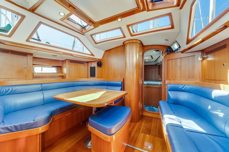 Liberte' Yacht Photos Pics Luxurious interior of 2011 Hylas 46 yacht with blue seating and wooden finishes.