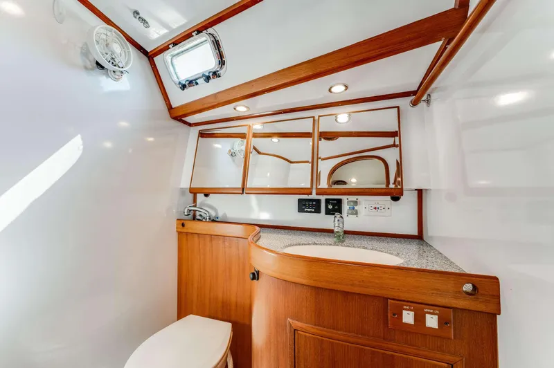 Liberte' Yacht Photos Pics Luxurious bathroom interior of 2011 Hylas 46 yacht with wooden cabinetry and modern fixtures.