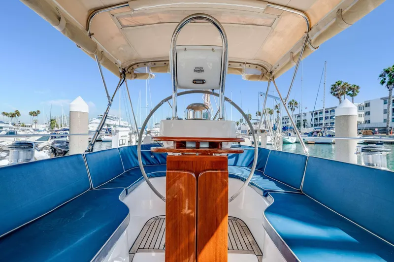 Liberte' Yacht Photos Pics Interior view of 2011 Hylas 46 sailboat with blue seating and wooden helm.