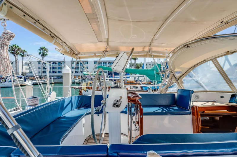 Liberte' Yacht Photos Pics 2011 Hylas 46 yacht interior with blue seating, docked in a marina.