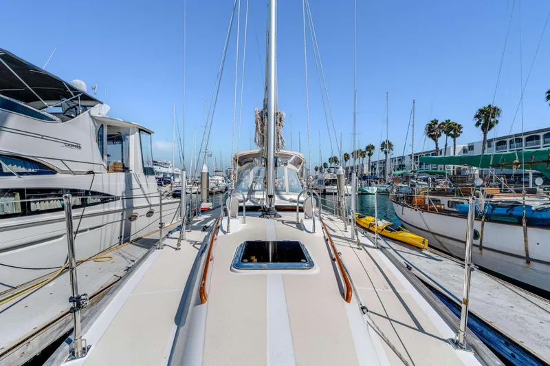 Liberte' Yacht Photos Pics Hylas 46 sailboat docked at marina, 2011 model, clear sky, palm trees in background.
