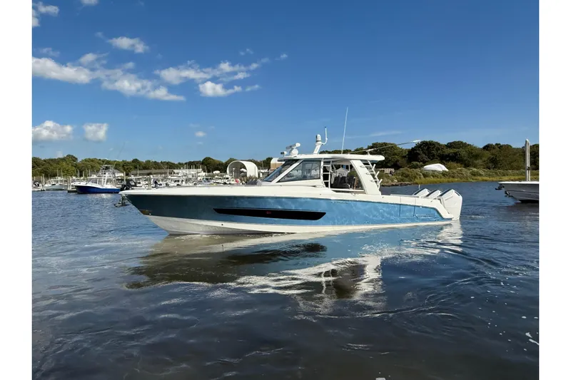  Yacht Photos Pics 2024 Boston Whaler 420 Outrage boat on calm water under clear blue sky.