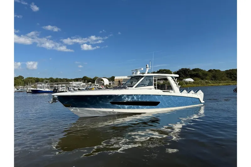  Yacht Photos Pics 2024 Boston Whaler 420 Outrage boat on calm water under clear blue sky.