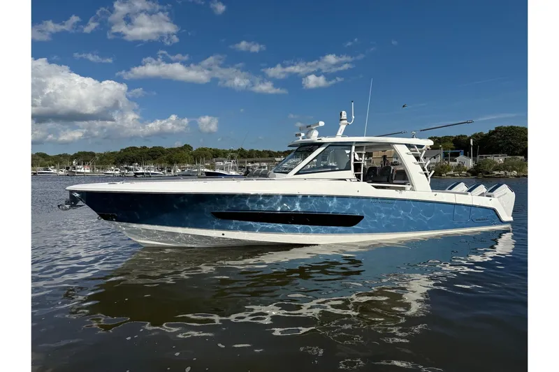  Yacht Photos Pics 2024 Boston Whaler 420 Outrage boat on calm water under a clear blue sky.