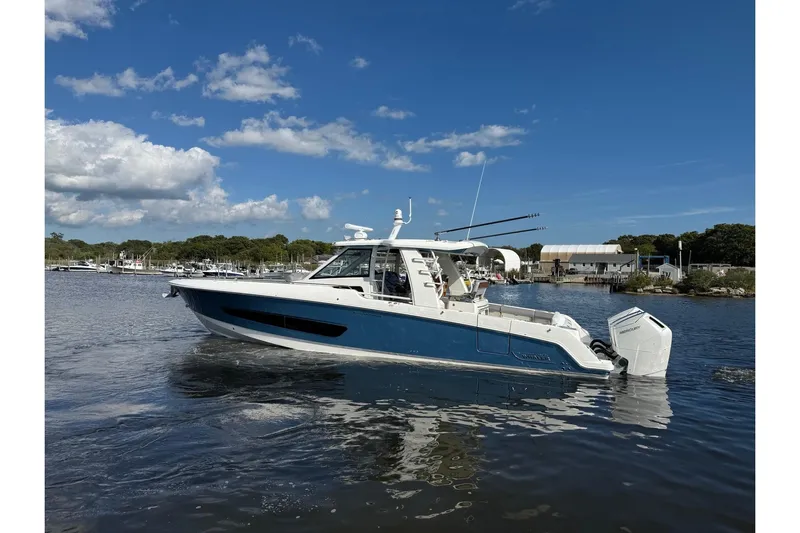  Yacht Photos Pics 2024 Boston Whaler 420 Outrage boat on calm water under blue sky.