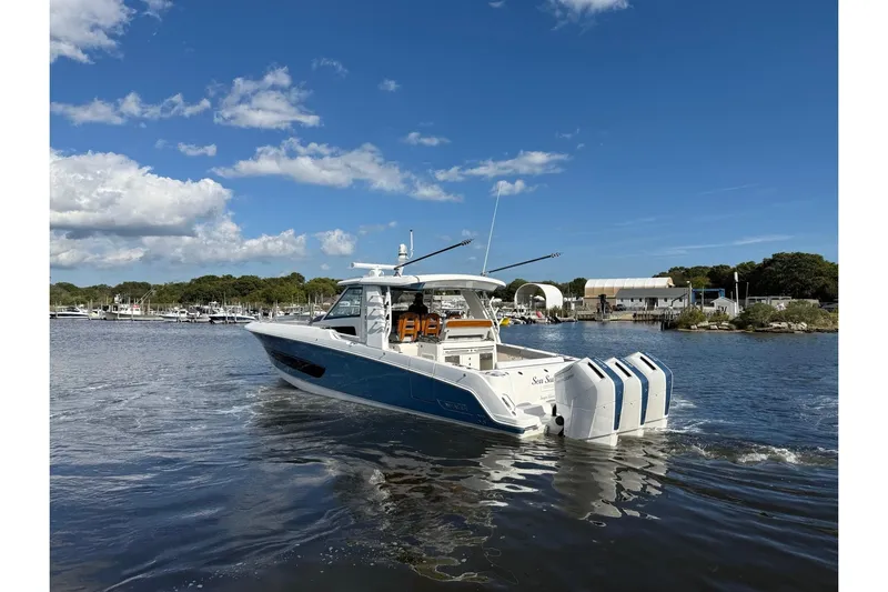  Yacht Photos Pics 2024 Boston Whaler 420 Outrage cruising on a sunny day near a marina.