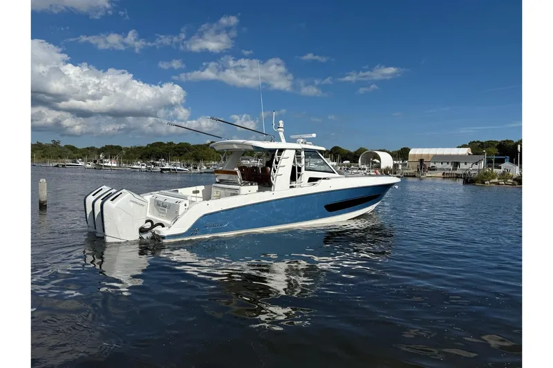  Yacht Photos Pics 2024 Boston Whaler 420 Outrage boat on calm water under a clear blue sky.