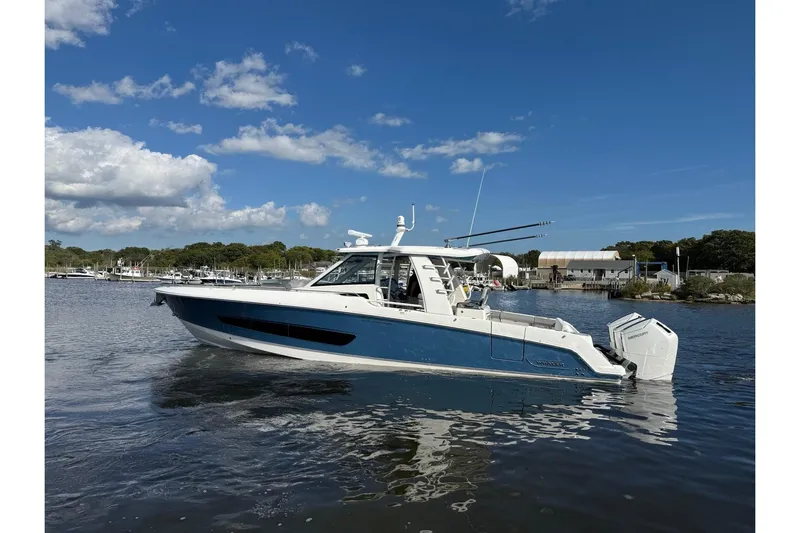  Yacht Photos Pics 2024 Boston Whaler 420 Outrage boat on calm water under a clear blue sky.
