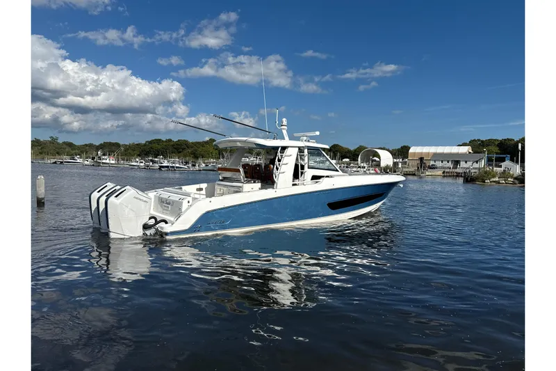  Yacht Photos Pics 2024 Boston Whaler 420 Outrage boat on calm water under a clear blue sky.