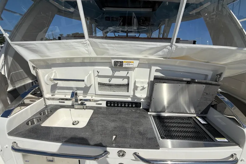  Yacht Photos Pics 2024 Boston Whaler 420 Outrage boat kitchen with sink, grill, and storage.