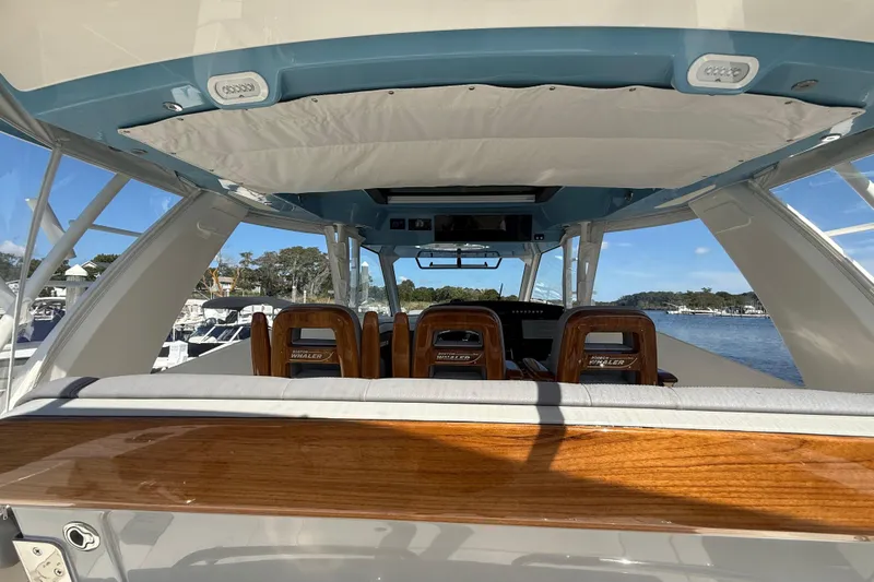  Yacht Photos Pics 2024 Boston Whaler 420 Outrage interior with wooden accents and scenic water view.