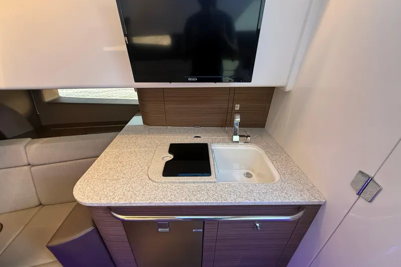  Yacht Photos Pics 2024 Boston Whaler 420 Outrage interior with modern kitchenette and TV.