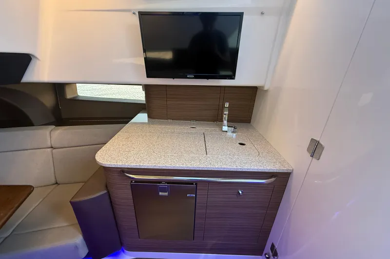  Yacht Photos Pics 2024 Boston Whaler 420 Outrage interior with kitchenette, TV, and seating area.