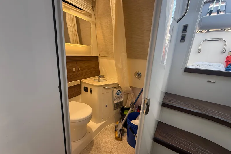  Yacht Photos Pics 2024 Boston Whaler 420 Outrage bathroom interior with modern fixtures and wooden accents.