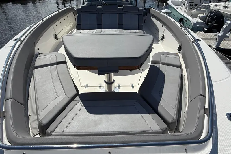  Yacht Photos Pics 2024 Boston Whaler 420 Outrage boat interior with cushioned seating and table.