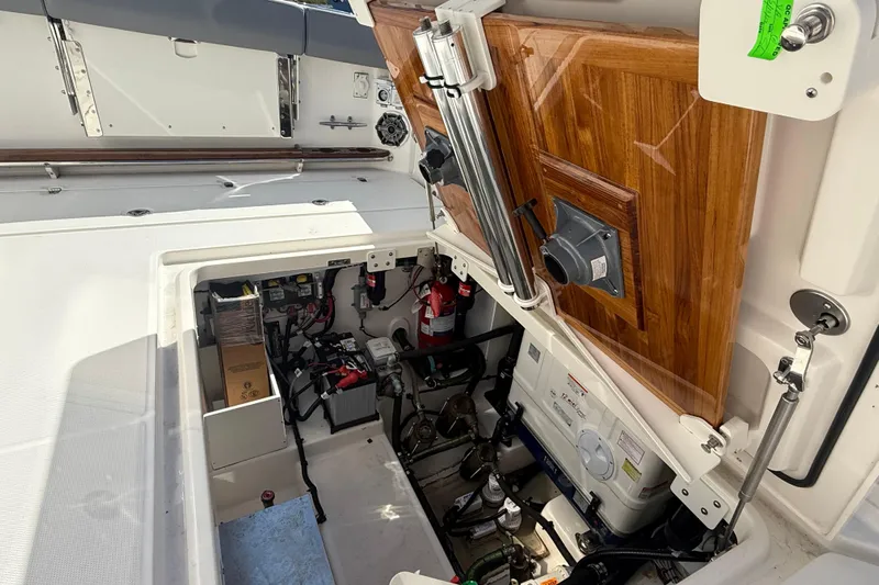  Yacht Photos Pics 2024 Boston Whaler 420 Outrage engine compartment with open wooden hatch and visible equipment.