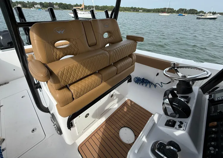  Yacht Photos Pics 2020 Southport 33 FE boat interior with tan leather seating and steering wheel, docked on calm water.