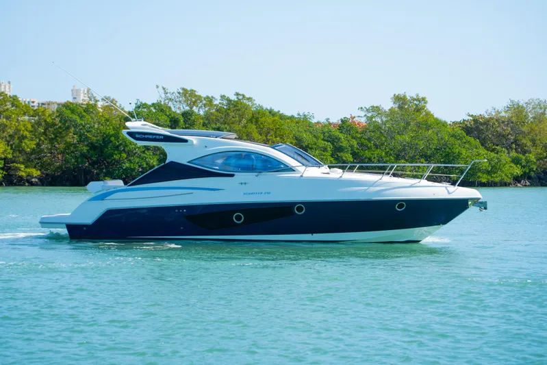  Yacht Photos Pics 2022 Schaefer 375 HT yacht cruising on a serene waterway with lush greenery.