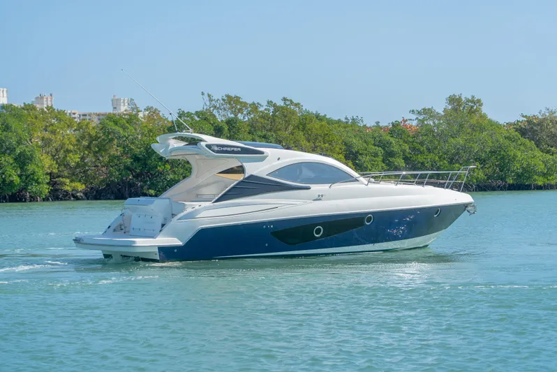  Yacht Photos Pics 2022 Schaefer 375 HT yacht cruising on a serene waterway with lush greenery.