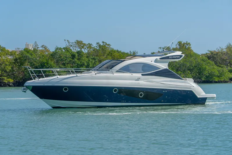  Yacht Photos Pics 2022 Schaefer 375 HT yacht cruising on calm water, surrounded by lush greenery.