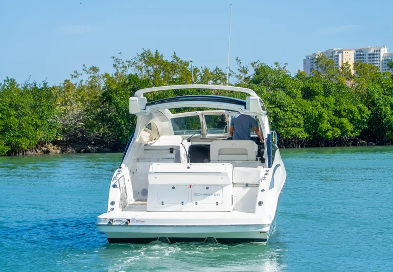  Yacht Photos Pics Schaefer 375 HT 2022 boat cruising on clear water near lush greenery.