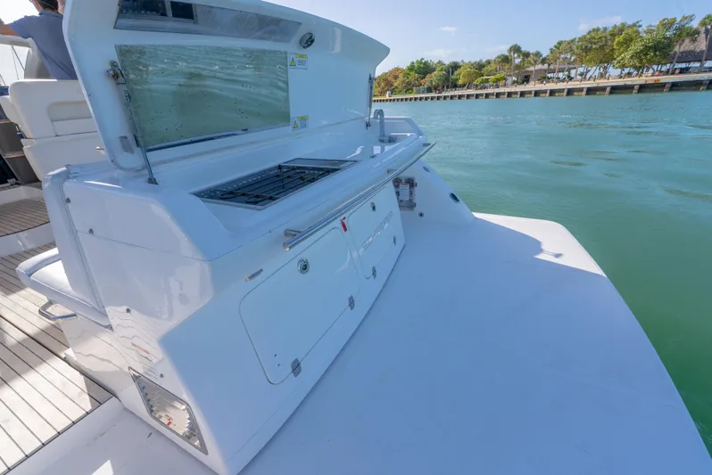  Yacht Photos Pics 2022 Schaefer 375 HT yacht with outdoor kitchen, docked by a scenic waterfront.