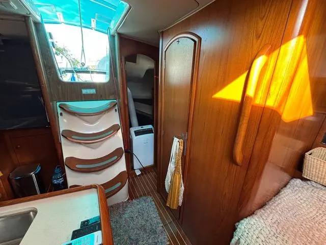  Yacht Photos Pics Interior of 2002 Jeanneau Sun Odyssey 40 sailboat with wooden finishes and natural light.