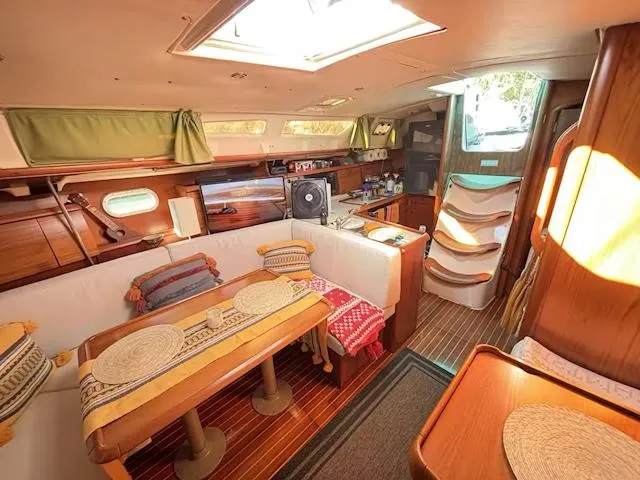  Yacht Photos Pics Interior of 2002 Jeanneau Sun Odyssey 40 sailboat with cozy seating and dining area.
