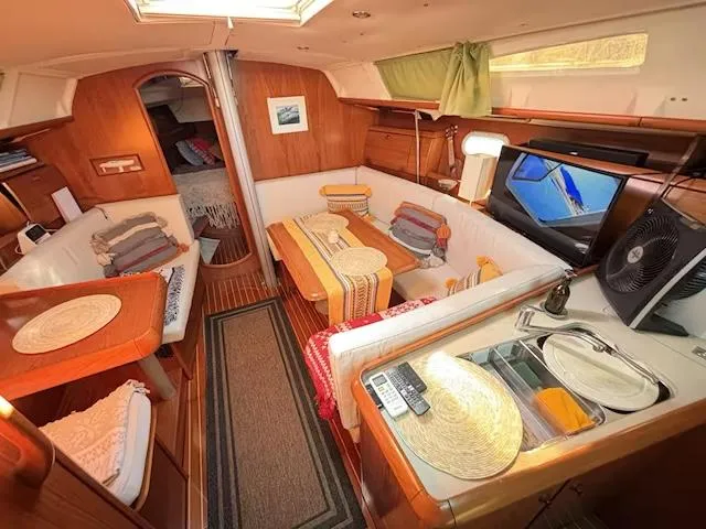  Yacht Photos Pics Interior of 2002 Jeanneau Sun Odyssey 40 sailboat with cozy seating and wooden finishes.