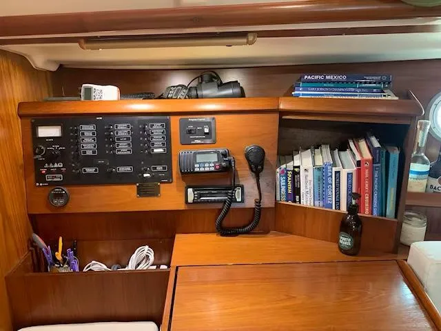  Yacht Photos Pics 2002 Jeanneau Sun Odyssey 40 interior with navigation panel, books, and communication equipment.