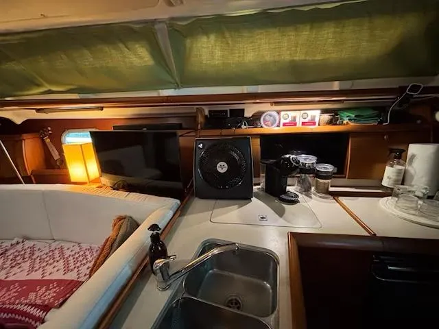  Yacht Photos Pics Interior of 2002 Jeanneau Sun Odyssey 40 yacht with cozy seating and kitchen amenities.