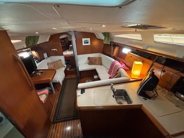  Yacht Photos Pics Interior of 2002 Jeanneau Sun Odyssey 40 sailboat with cozy seating and kitchenette.