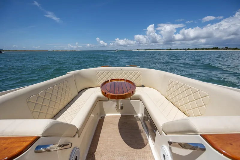  Yacht Photos Pics Luxurious 2022 Chris-Craft Launch 27 boat interior with elegant seating and wooden table.