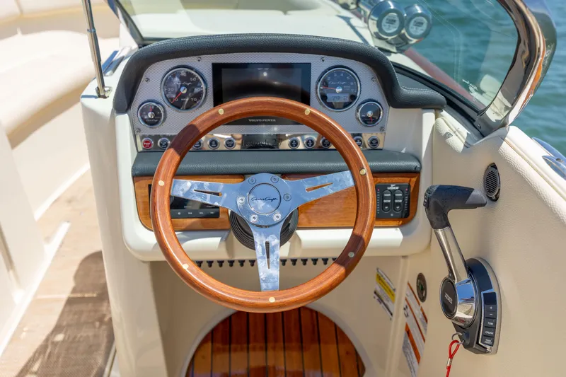  Yacht Photos Pics 2022 Chris-Craft Launch 27 dashboard with wooden steering wheel and modern controls.