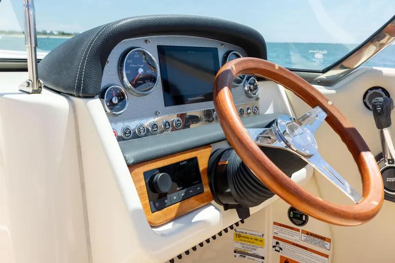  Yacht Photos Pics Dashboard of 2022 Chris-Craft Launch 27 boat with wooden steering wheel and modern controls.