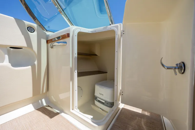 Yacht Photos Pics 2022 Chris-Craft Launch 27 interior with compact marine toilet and storage space.