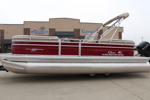 2025 Sun Tracker Party Barge 22 DLX pontoon boat, red and white, parked outside dealership.
